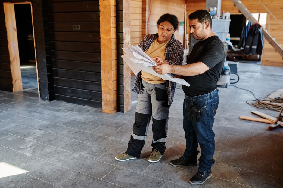General contractor team reviewing architectural blueprints for a home renovation